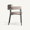 La silla de comedor moderna tapizada y de acero Albula cuenta con un cómodo asiento y respaldo texturizado en beige, sostenidos por elegantes patas de metal negro. Ideal para espacios modernos, combina estilo y comodidad con un fondo neutro.