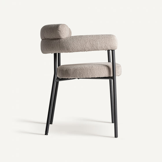 La silla de comedor moderna tapizada y de acero Albula cuenta con un cómodo asiento y respaldo texturizado en beige, sostenidos por elegantes patas de metal negro. Ideal para espacios modernos, combina estilo y comodidad con un fondo neutro.