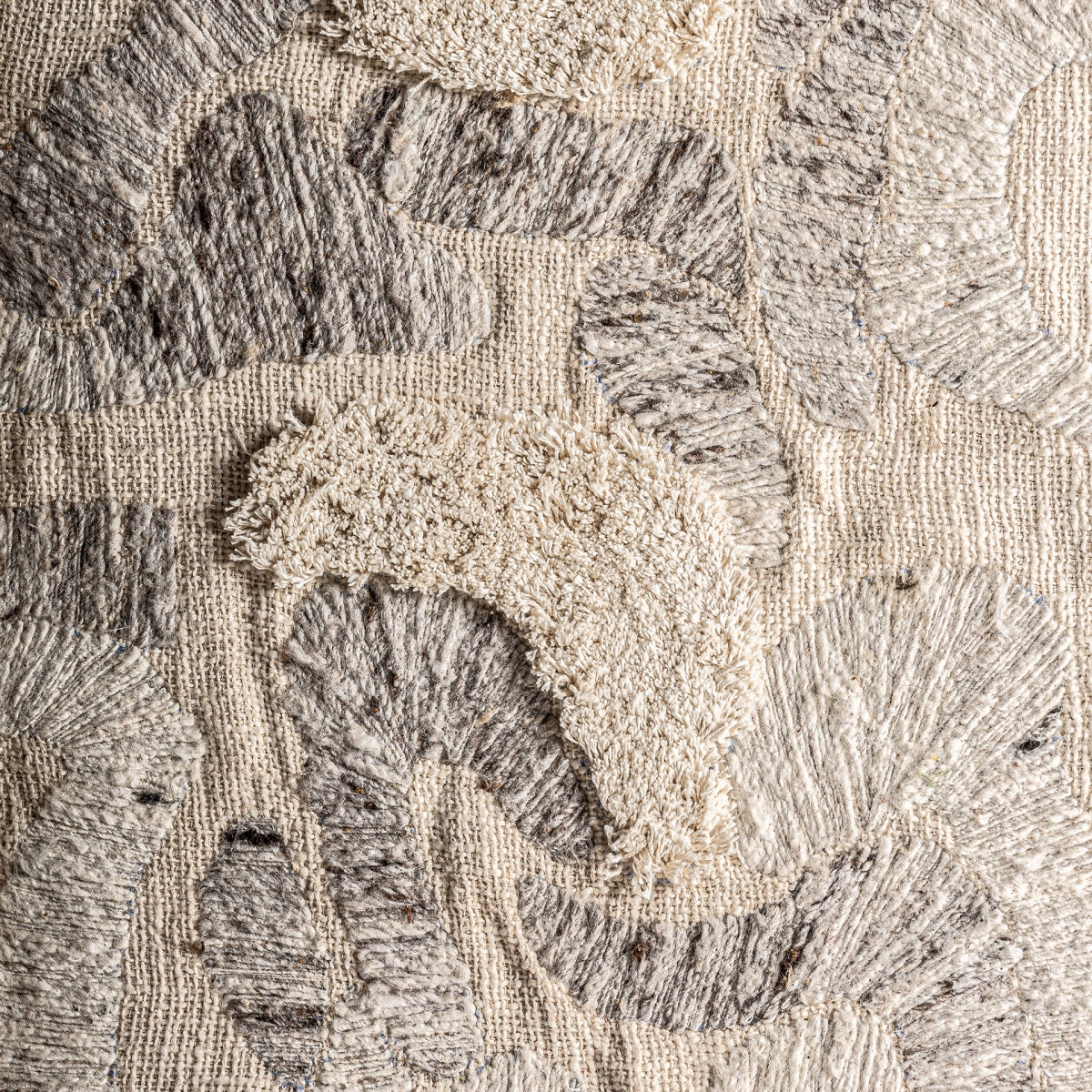Primer plano del Cuadro en madera de mango y algodón relieve tonos claros Bram, que presenta tela texturizada con patrones abstractos en beige y gris, un diseño artesanal perfecto para la decoración del hogar.