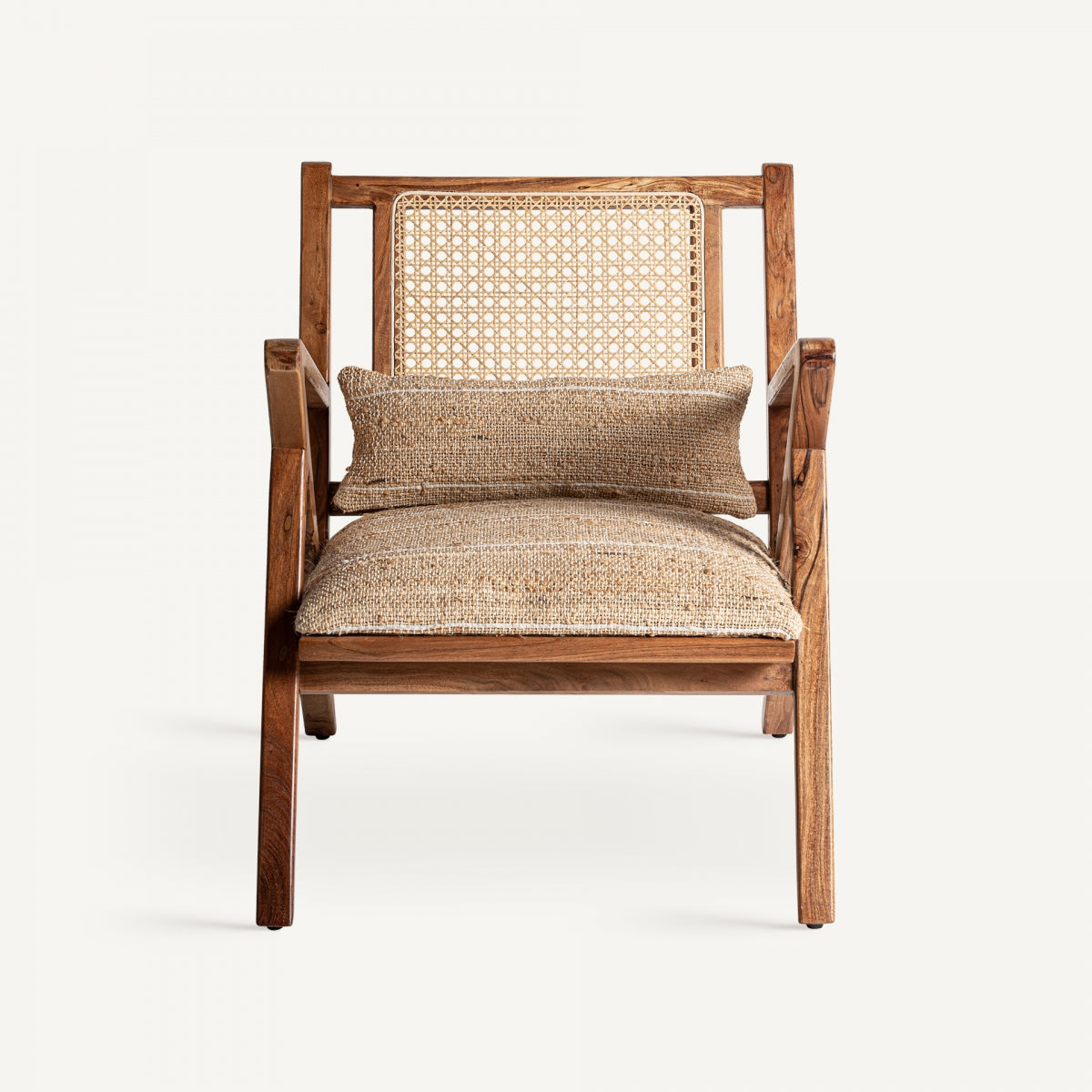 El Sillón bohemio con detalles en arena y madera de mango Hickory cuenta con una resistente estructura de madera de mango, respaldo de caña tejida y cojín texturizado con almohada lumbar. Su estilo bohemio se destaca a la perfección sobre un fondo liso.