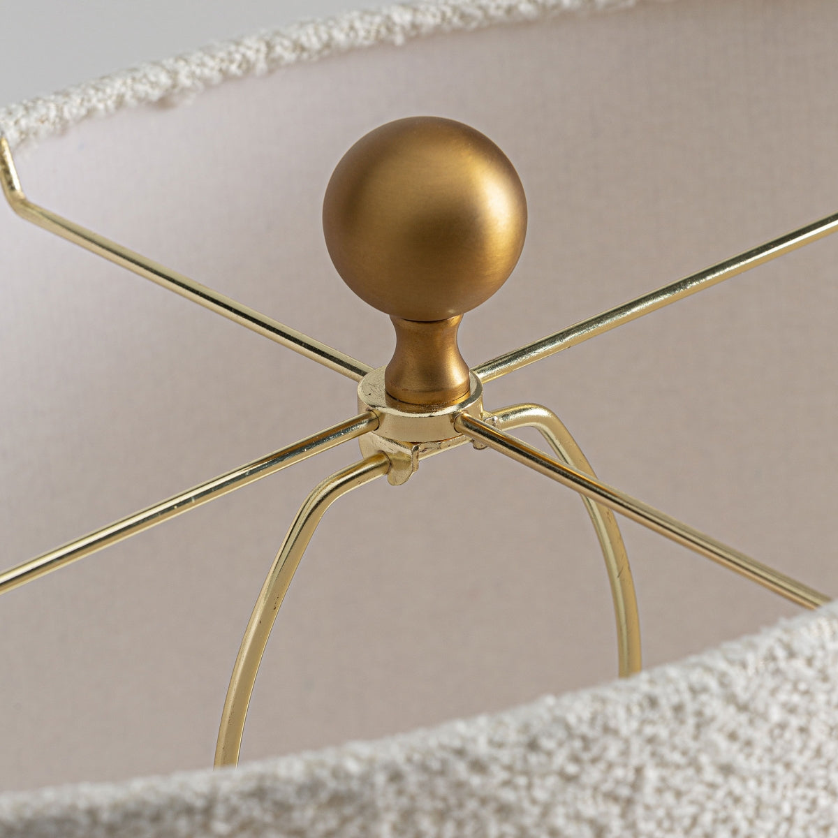 Un primer plano de la pantalla de algodón revela una estructura de metal dorado y un remate redondo. Ideal para la lámpara de mesa contemporánea de mármol y bronce V-iva, este elegante diseño complementa su elegante base de mármol.