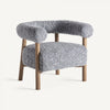 El Sillón tapizado y madera de fresno Allitz es un sillón gris contemporáneo que presenta un respaldo curvo y patas de madera, tapizado en un material suave y texturizado para brindar elegancia y comodidad en cualquier espacio habitable.