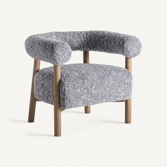 El Sillón tapizado y madera de fresno Allitz es un sillón gris contemporáneo que presenta un respaldo curvo y patas de madera, tapizado en un material suave y texturizado para brindar elegancia y comodidad en cualquier espacio habitable.