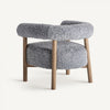 El sillón tapizado y madera de fresno Allitz combina comodidad y diseño contemporáneo con su tapizado gris lujoso, textura vellosa, respaldo redondeado y patas de madera sobre un fondo blanco liso.