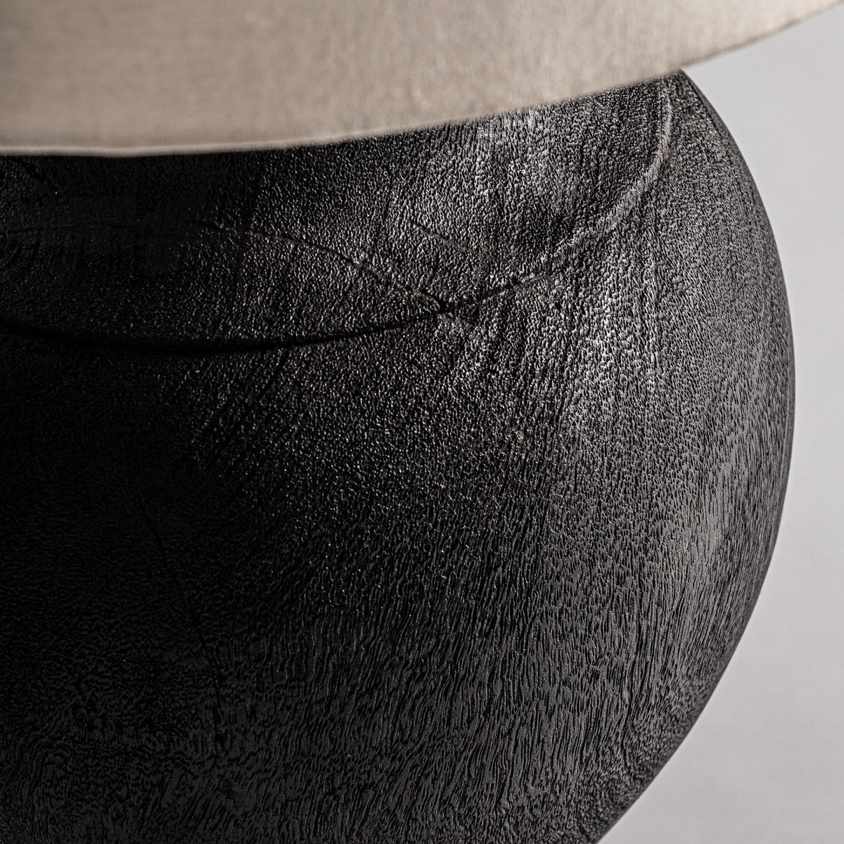 Un primer plano de la Lámpara de sobremesa en madera de mango Ligia, con su veta de madera natural y su acabado liso sobre un fondo neutro, evoca la elegancia artesanal y sutiles toques de diseño colonial.