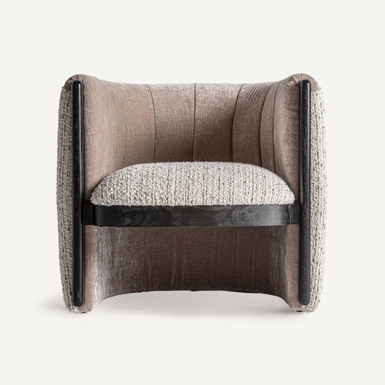 El Sillón tapizado jaspeado Erbach TN, hecho de madera de pino, luce un diseño contemporáneo con respaldo curvo y brazos oscuros, brindando elegancia y confort en su tapizado beige texturizado sobre fondo blanco.