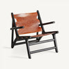 El sillón en madera de mango y piel Bourthes, con su estructura oscura, asiento y respaldo de color marrón rojizo, apoyabrazos y diseño angular robusto, irradia un encanto vintage que recuerda al estilo clásico de Bourthes.