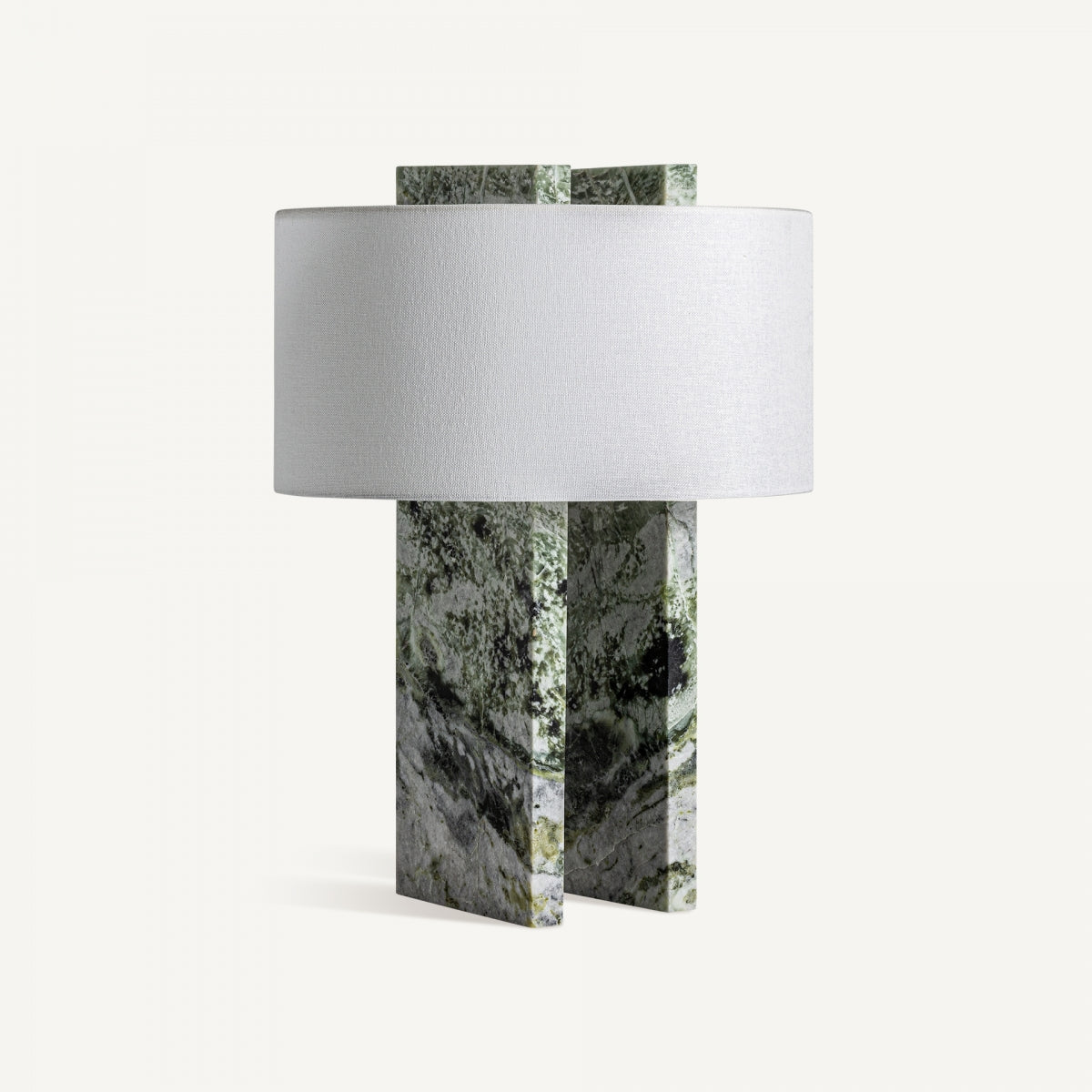 La Lámpara de mesa en mármol Verdea tiene una pantalla cilíndrica blanca y base de losas verdes y grises entrecruzadas, con diseño art deco para aportar elegancia a cualquier ambiente.