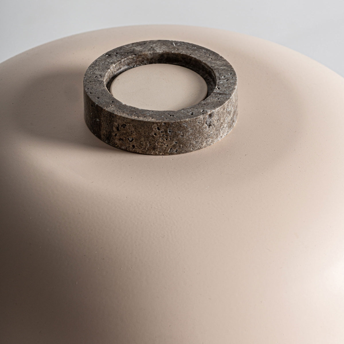 Primer plano de la Lámpara de sobremesa en bronce y mármol Graf, que presenta una cúpula suave de color beige, un anillo circular de mármol en el centro superior, estilo art déco y un elegante acabado en bronce gris.