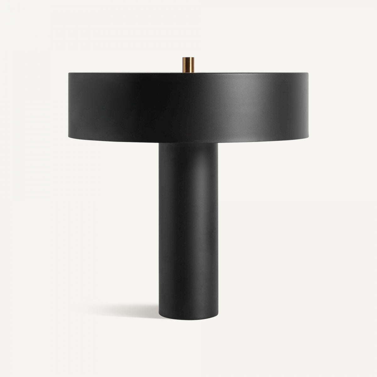 La Lámpara de mesa en bronce negro Must presenta una base cilíndrica y pantalla ancha y plana con elementos Art Deco, destacando su moderno diseño sobre un fondo blanco.