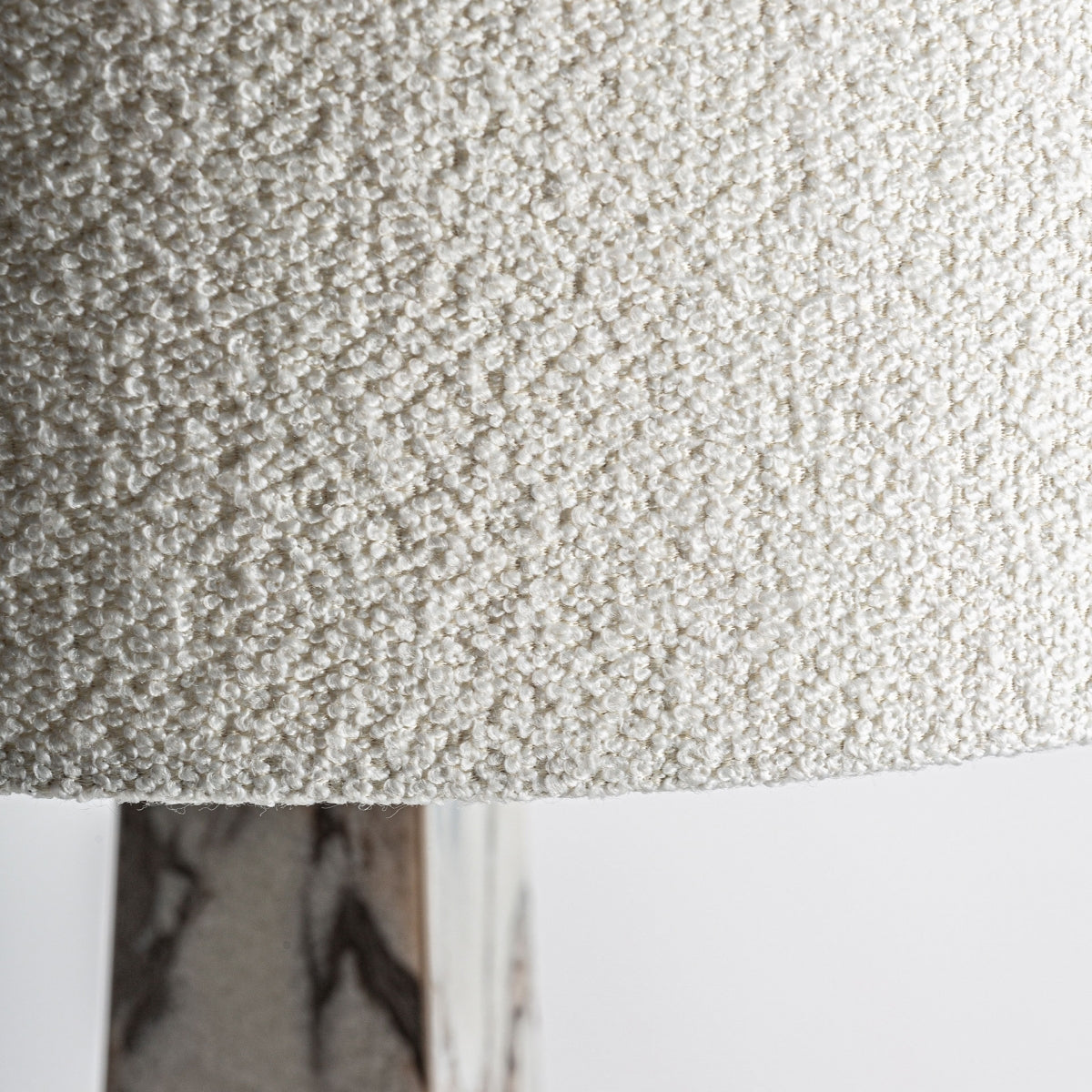 Primer plano de la pantalla texturizada de color blanco roto de la Lámpara de pie art decó en bronce y mármol Galia, con parte de su base de bronce y mármol visible y reflejando un sutil diseño art decó.