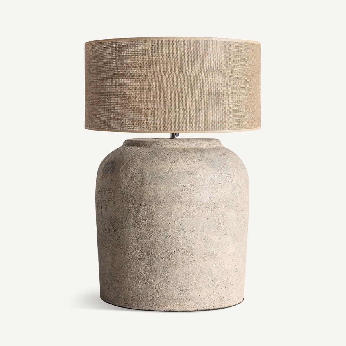 La Lámpara de sobremesa en terracota y yute Abila luce una base ancha de terracota texturizada y pantalla cilíndrica de yute beige, mostrando un diseño contemporáneo sobre fondo blanco.