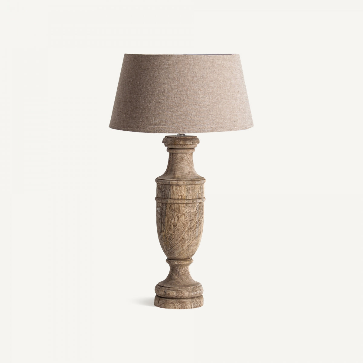 Lámpara de sobremesa en madera de mango y algodón Lynda, de estilo clásico, con base tallada y pantalla beige, sobre fondo blanco.