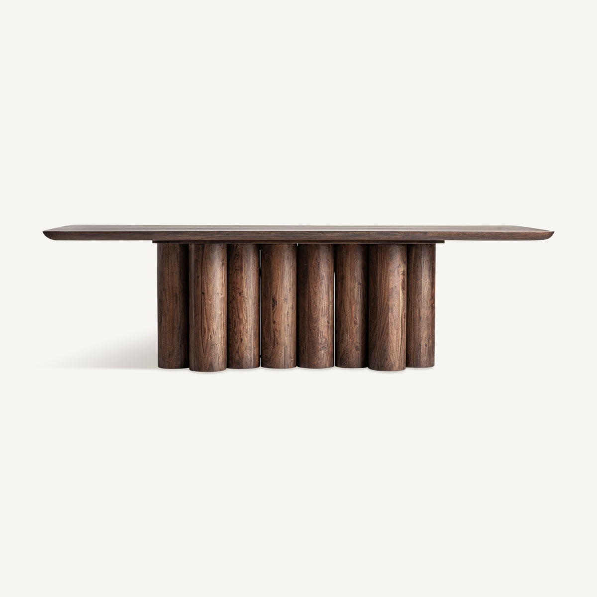 La mesa de comedor en madera de acacia Beke es una gran mesa rectangular que presenta un tablero de madera oscura y una base hecha de columnas cilíndricas verticales, todo elaborado con elegante madera de acacia.