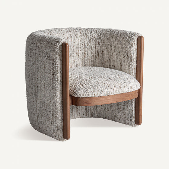 El Sillón tapizado en jaspeado Erbach - Madera de pino combina tapizado gris jaspeado y detalles de madera de pino, ofreciendo un estilo art deco contemporáneo y confort moderno sobre fondo blanco.