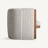 Un sillón tapizado en jaspeado Erbach - Madera de pino en color beige claro, con tapizado texturizado y un panel lateral de madera de pino, se muestra de lado sobre un fondo liso.