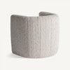 Sillón moderno tapizado en jaspeado Erbach - Madera de pino, con silueta curva y tejido texturizado beige claro, que se muestra sobre un fondo blanco liso.