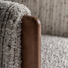 Primer plano de un apoyabrazos de madera de pino con una manta de punto texturizada en gris claro, resaltando el diseño art déco contemporáneo del Sillón tapizado en jaspeado Erbach en el fondo tapizado a juego.