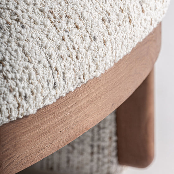 Primer plano del tapizado en tela texturizada color crema del Sillón tapizado en jaspeado Erbach - Madera de pino, resaltando su estilo Art Decó contemporáneo y sus elegantes acentos en madera de pino.