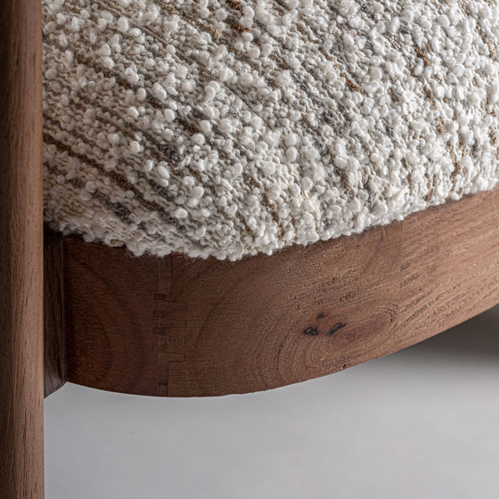 Primer plano del Sillón tapizado en jaspeado Erbach, elaborado en madera de pino con carpintería vista y tapizado texturizado en color crema, mostrando un diseño art decó contemporáneo.