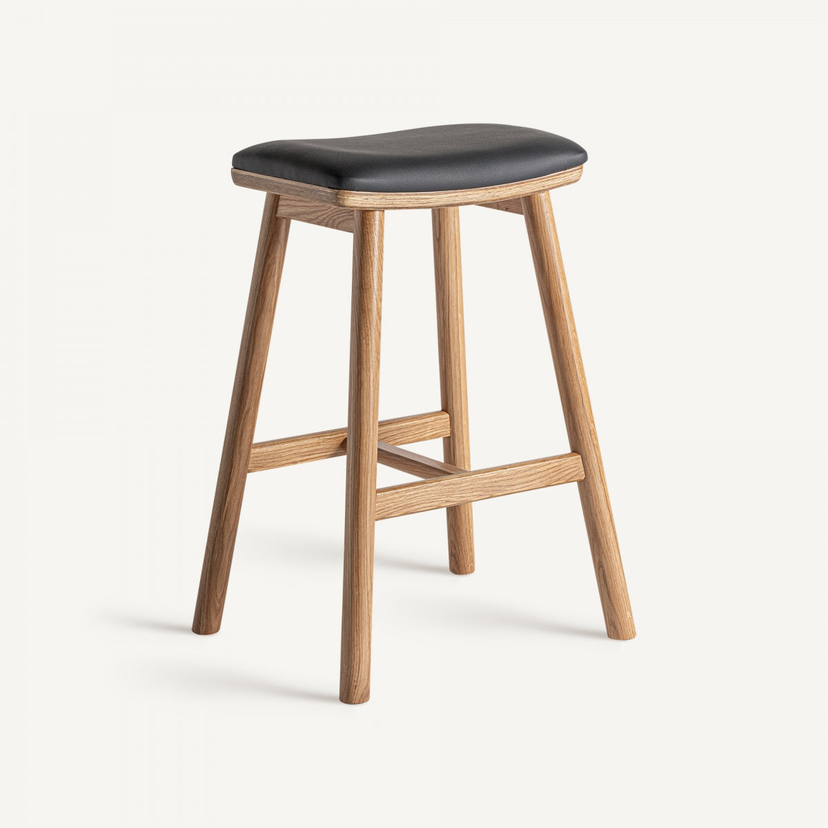El Taburete alto 68 cm en roble y polipiel Marciac ofrece un estilo vintage con un asiento acolchado negro sobre fuertes patas de roble sostenidas por elegantes vigas.