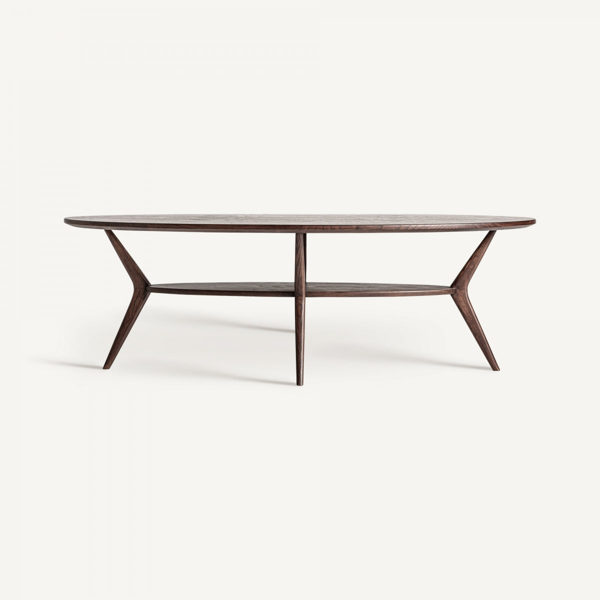 La mesa de centro en fresno Terborg es una elegante mesa de centro ovalada de madera con patas delgadas y un práctico estante inferior, presentada sobre un fondo blanco liso.