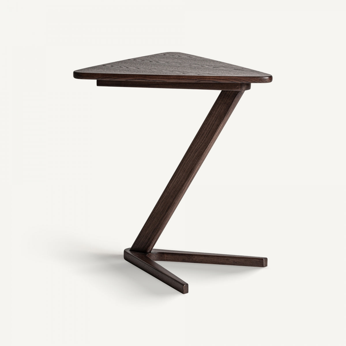 La mesa auxiliar estilo Art Deco en madera de fresno Aitrach es una mesa auxiliar triangular de madera de fresno intenso, que presenta un soporte de patas en forma de Z oscuro, que combina el diseño moderno con el estilo Art Deco.