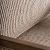 Primer plano del Sillón en madera de mango y mimbre Romarand, resaltando su elegancia clásica con tela tejida beige y marco de madera, mostrando texturas y fibras detalladas.