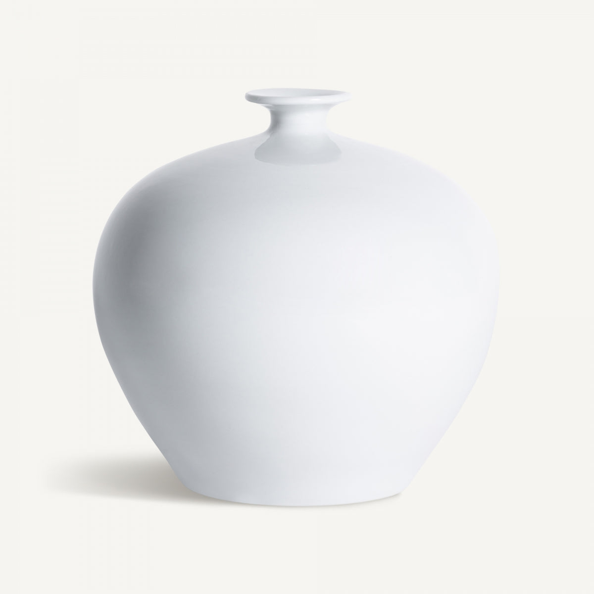 El Jarrón en cerámica blanca Jelen presenta un diseño redondo con cuello estrecho y cuerpo ancho, destacado sobre un fondo blanco en sutil estilo art déco.