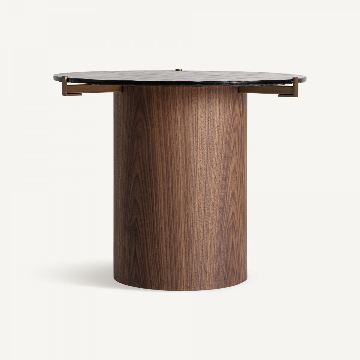 La "Mesa auxiliar en madera y cristal Giswil" presenta una base cilíndrica de madera y un tablero oscuro y texturizado, que captura la elegancia del estilo Art Deco.