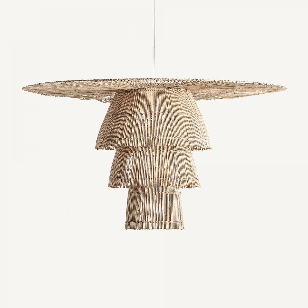 La Lámpara colgante en ratán marrón Boho 69 cuelga elegantemente de un cordón blanco sobre un fondo liso, derrochando estilo bohemio.