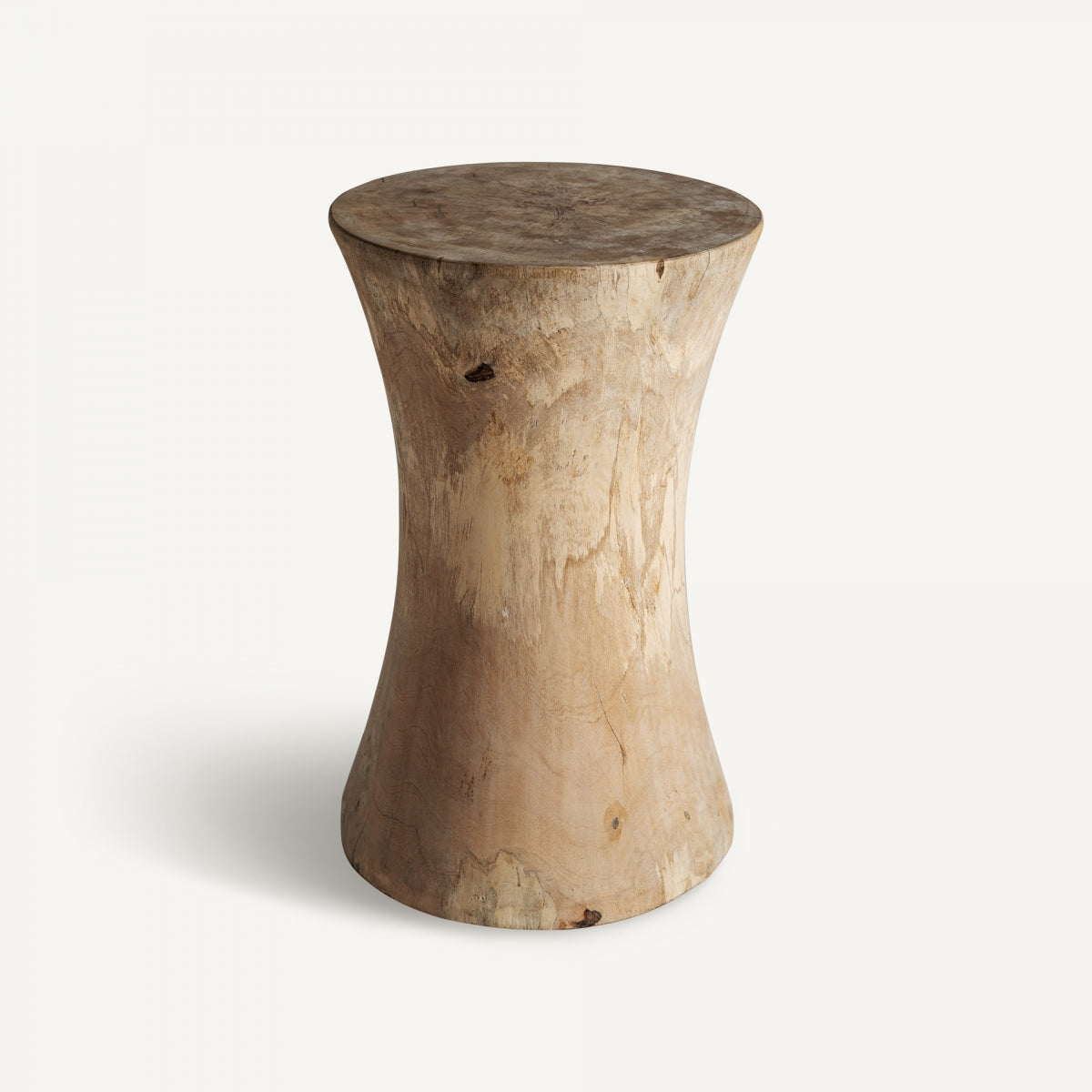El Taburete bajo en madera suar artesanal Guelma C presenta una forma suave de reloj de arena y un acabado natural, elaborado con exquisita madera suar, y se destaca elegantemente sobre un fondo blanco liso.
