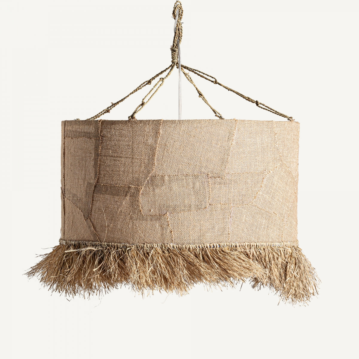 La "Lámpara colgante en yute Bohemia 71" presenta una superficie de tela texturizada de color beige con detalles de flecos, suspendida por cordones de yute, capturando un diseño bohemio único.