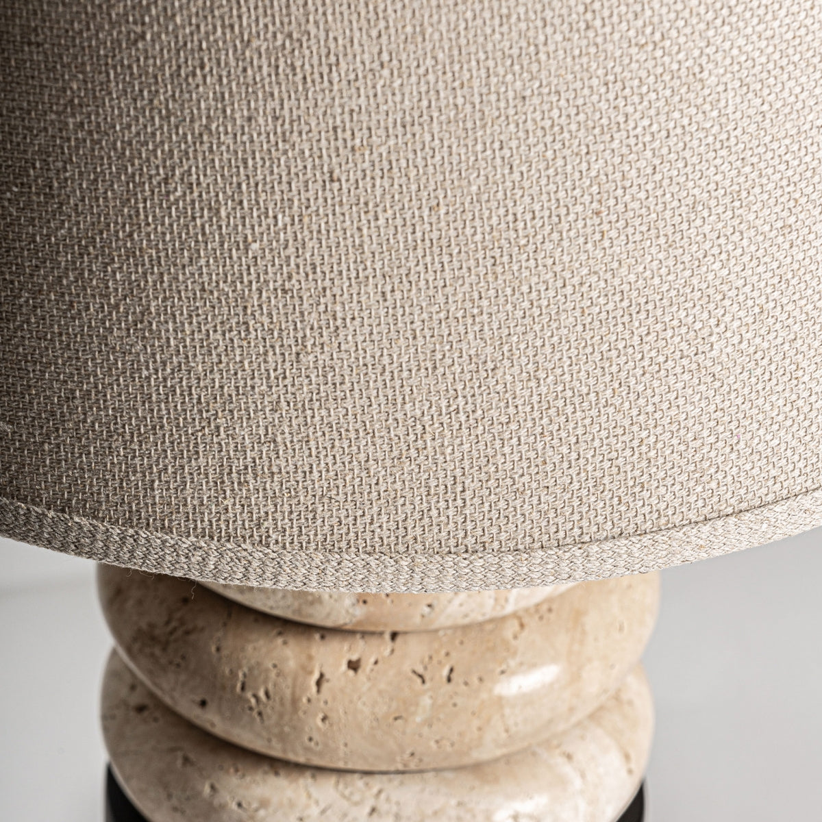 Primer plano de la Lámpara de sobremesa en hierro y mármol Kareen, con pantalla beige texturizada y base de piedra, mostrando cómo aporta sofisticación y materiales de calidad superior a cualquier ambiente.