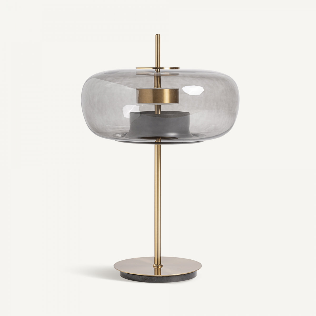 La Lámpara de mesa en metal dorado y cristal ahumado Grau destaca por su base circular, estructura de metal dorado y tulipa redonda de cristal gris ahumado con detalles geométricos art déco.