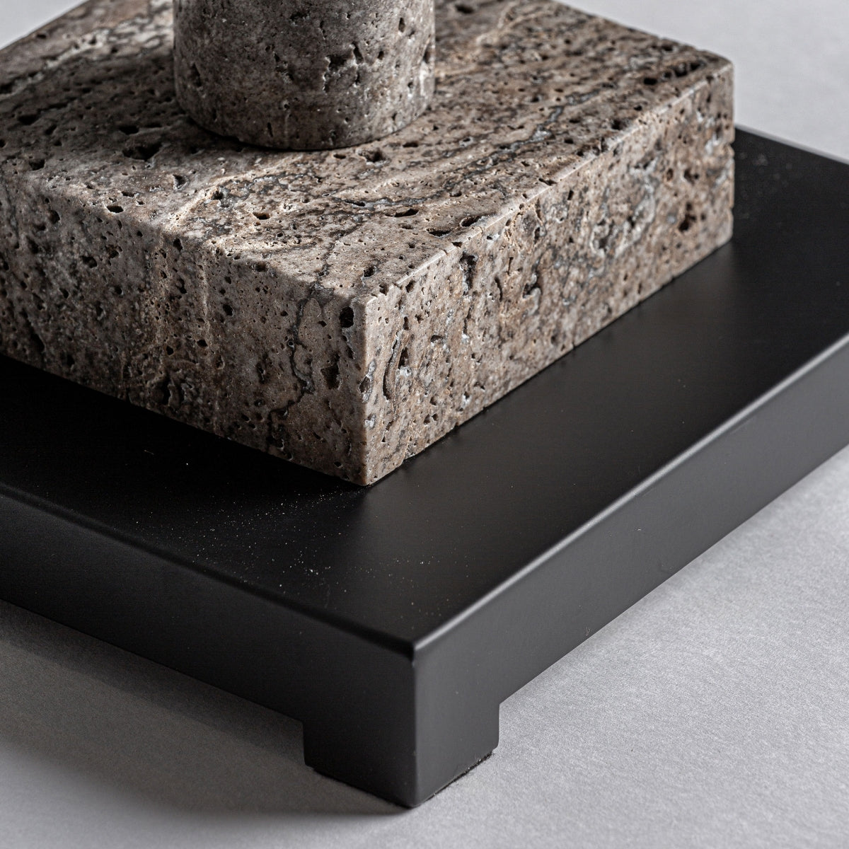 Primer plano de la Lámpara de pie en mármol e hierro Deco: un bloque de mármol gris texturizado con un poste cilíndrico de hierro sobre una base rectangular negra, que evoca la elegancia y funcionalidad del diseño Art Déco sobre un fondo gris claro.