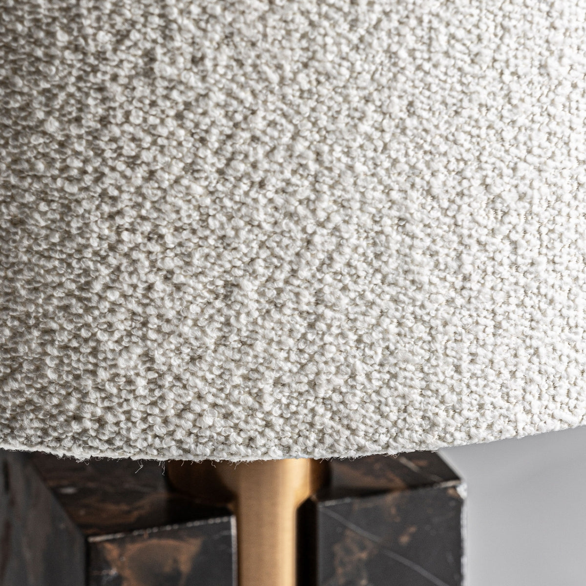 Primer plano de la Lámpara de mesa en mármol y hierro Artco con una pantalla blanquecina texturizada, varilla de latón y base de mármol marrón rectangular oscuro, perfecta para agregar diseño moderno a cualquier espacio.