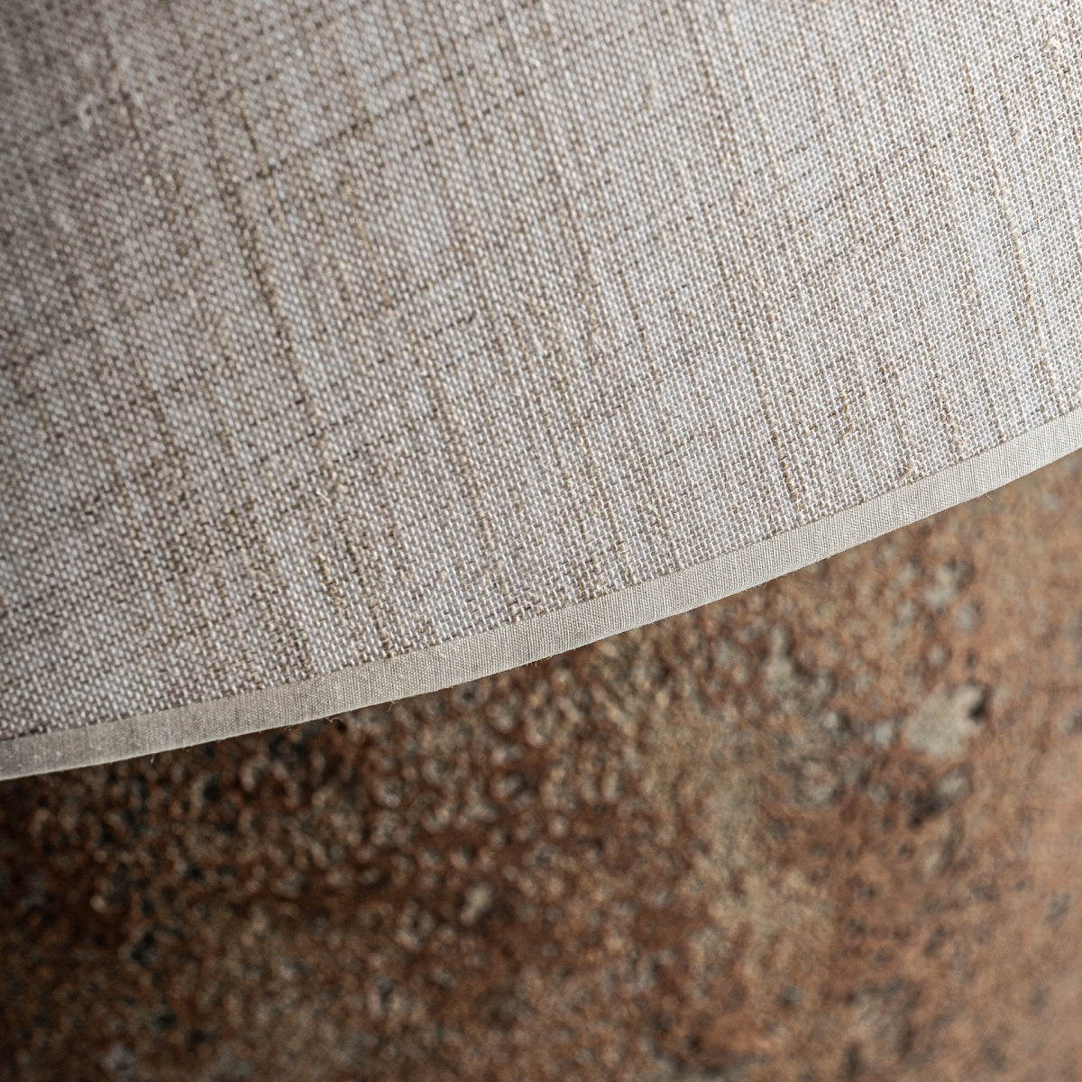 Primer plano de la pantalla texturizada de color beige y la base rugosa que parece piedra de la Lámpara de sobremesa en cerámica vintage Vinci, que evoca la cerámica hecha a mano, ideal para los fanáticos del diseño retro.