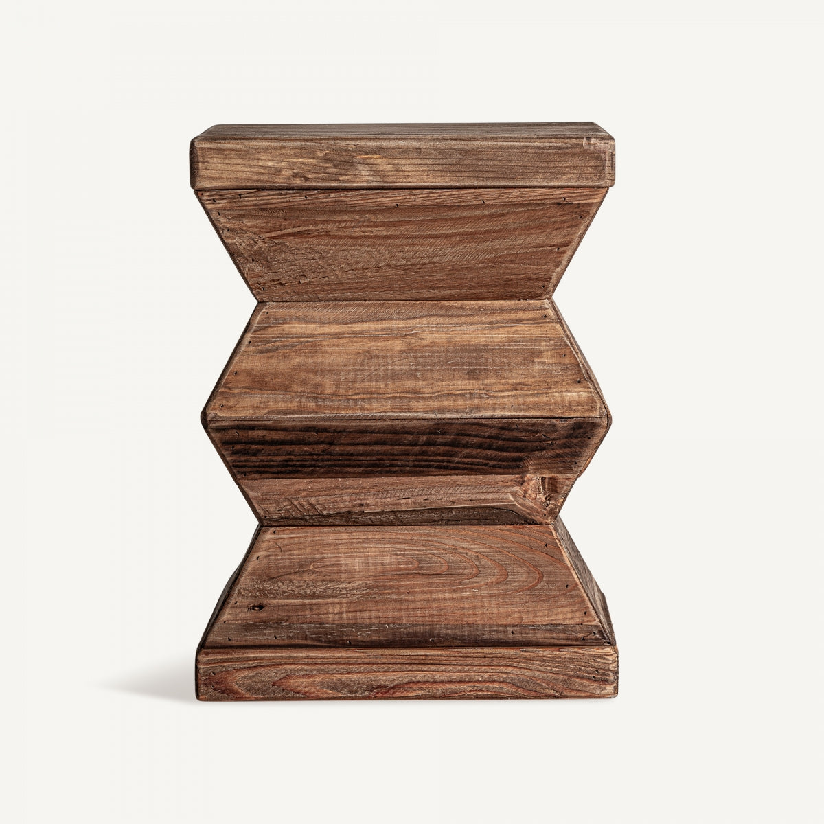 El taburete bajo Breive, elaborado a partir de madera reciclada con un acabado envejecido, presenta un diseño geométrico con bordes suaves y patrones de vetas de madera natural.