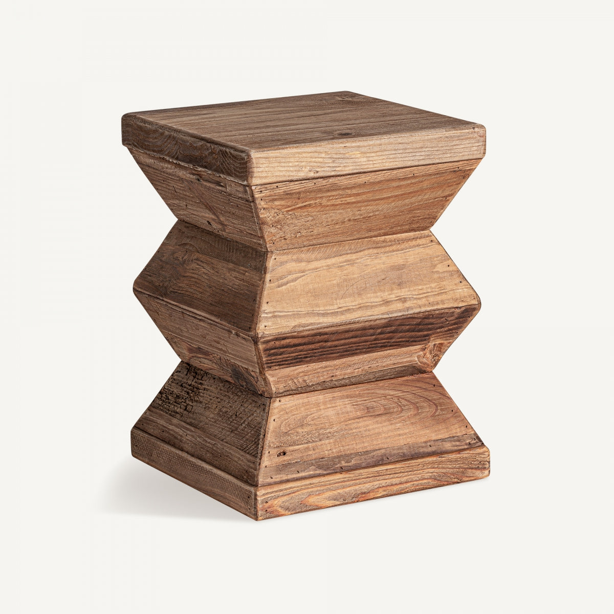 El Taburete bajo Breive presenta una forma de reloj de arena y una textura natural, elaborado meticulosamente por diseño artesanal utilizando madera reciclada con un acabado envejecido.