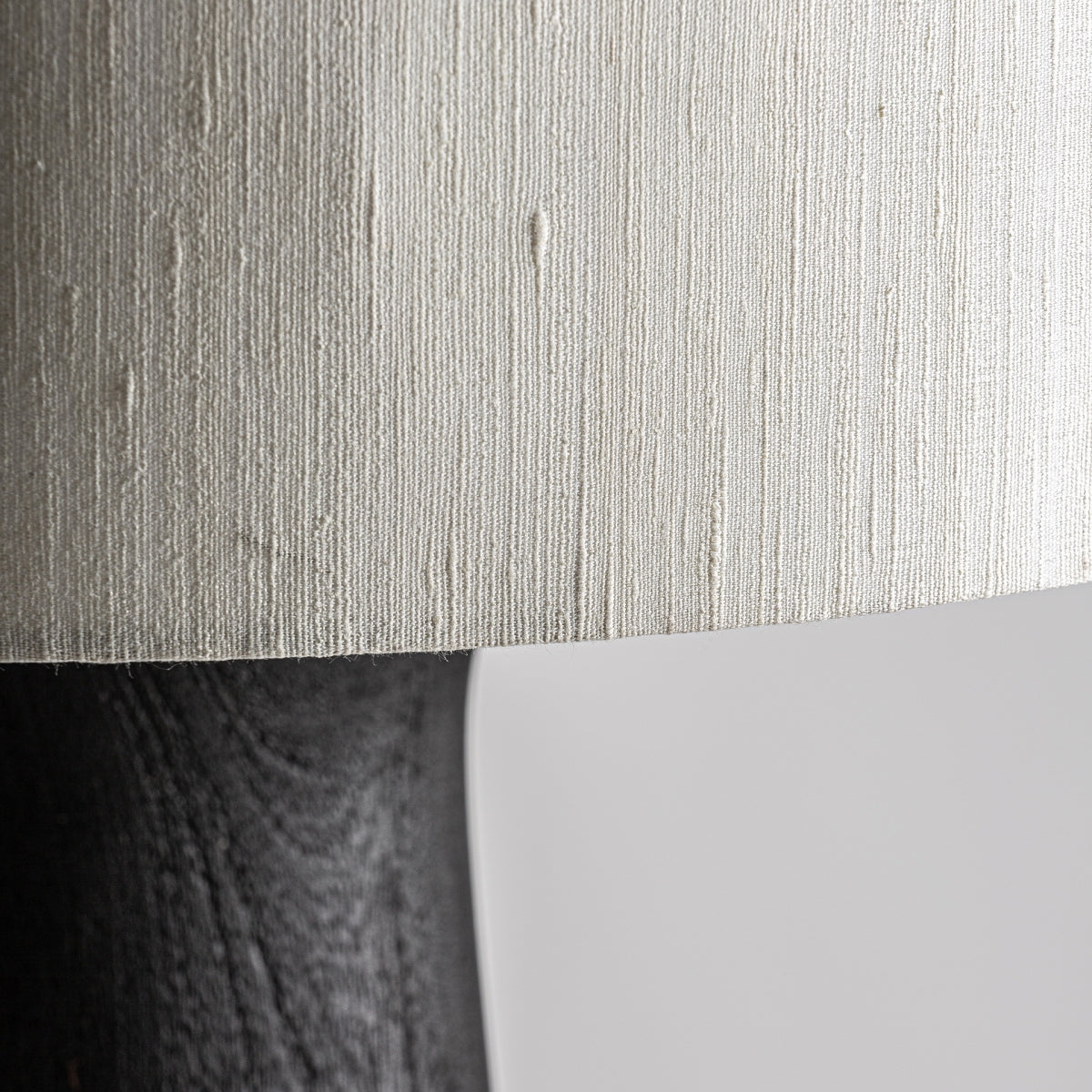 Primer plano de la pantalla de yute texturizada de color claro sobre la Lámpara de pie en madera de mango y yute Cogne de madera de mango oscuro, ideal para añadir calidez a cualquier interior.