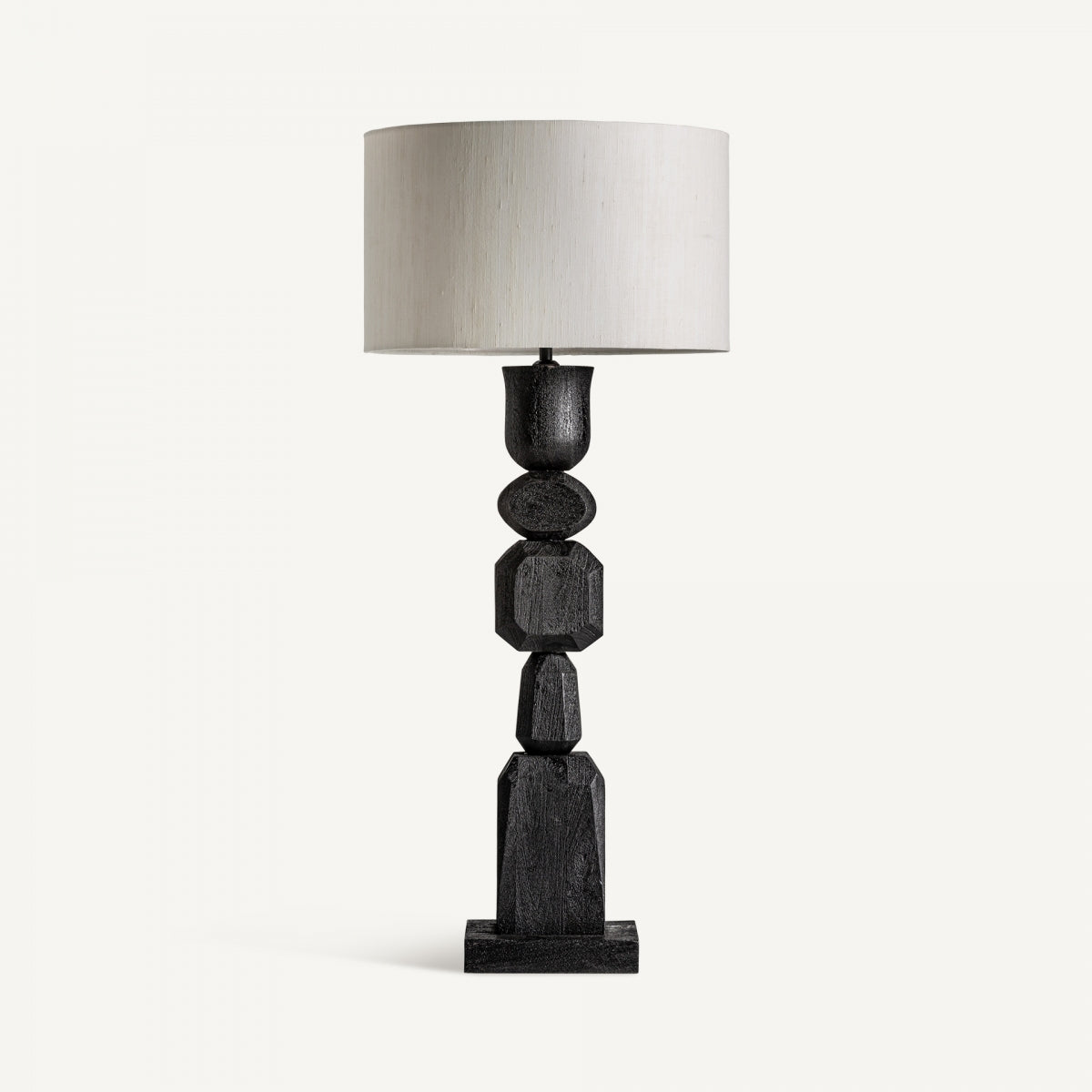 La lámpara de sobremesa en madera de mango Cogne N destaca por su base geométrica negra y gran pantalla cilíndrica blanca, realzando un diseño contemporáneo sobre fondo blanco.