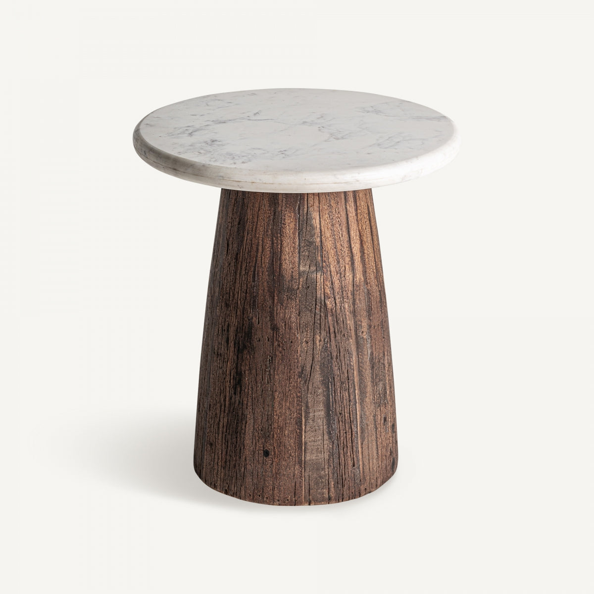 La "Mesa auxiliar en madera y mármol Skorup" es una pequeña mesa redonda con tapa de mármol blanco y base cónica elaborada con madera recuperada.