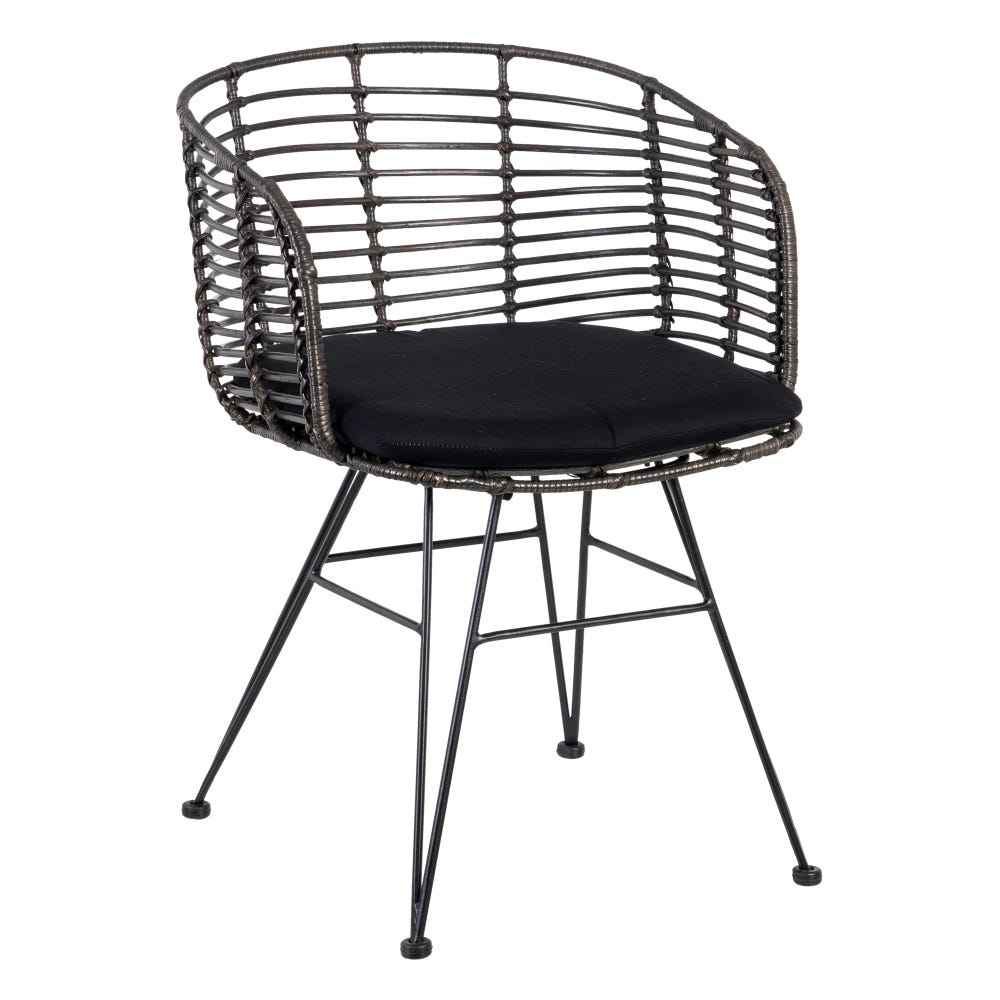 La Silla de Comedor en Ratán y Metal Nero presenta un diseño moderno e industrial con un marco de mimbre negro, respaldo redondeado, asiento con cojín negro y elegantes patas de metal.