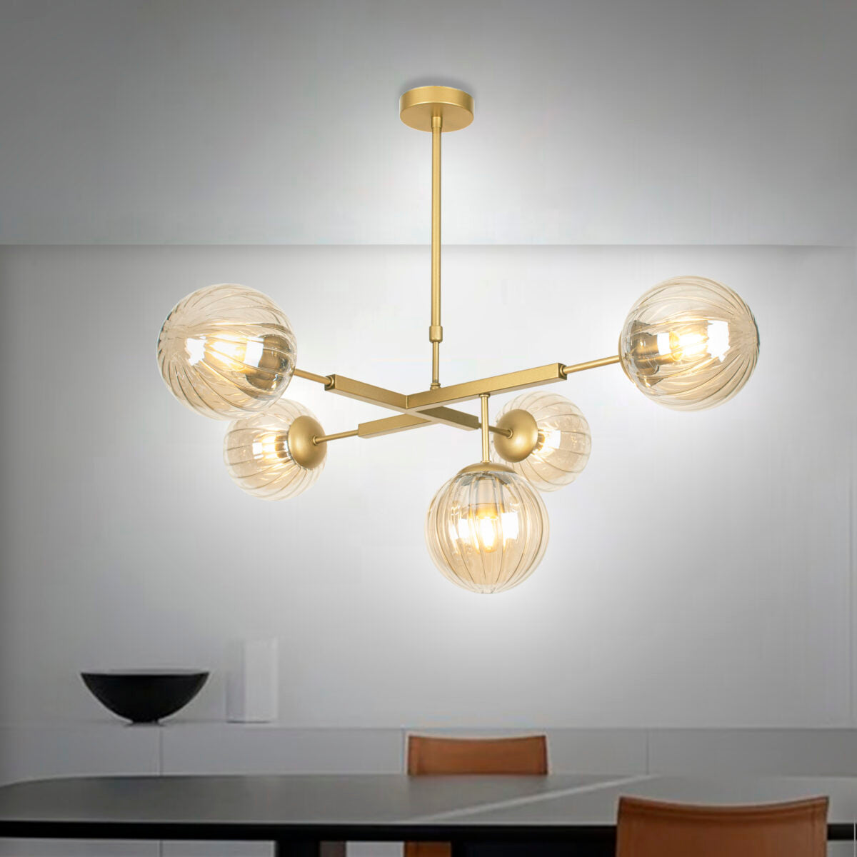 La lámpara de techo en acero y vidrio DT-Ball 5 cuenta con cinco luminarias esféricas de vidrio suspendidas de un marco de metal dorado, elaborado con acero de alta calidad, perfecto para un comedor minimalista.
