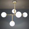 La Lámpara de techo en acero y vidrio T-Ball 5 cuenta con cinco luces tipo globo redondas de color blanco y un marco dorado, creando un elegante estilo contemporáneo que realza cualquier espacio.