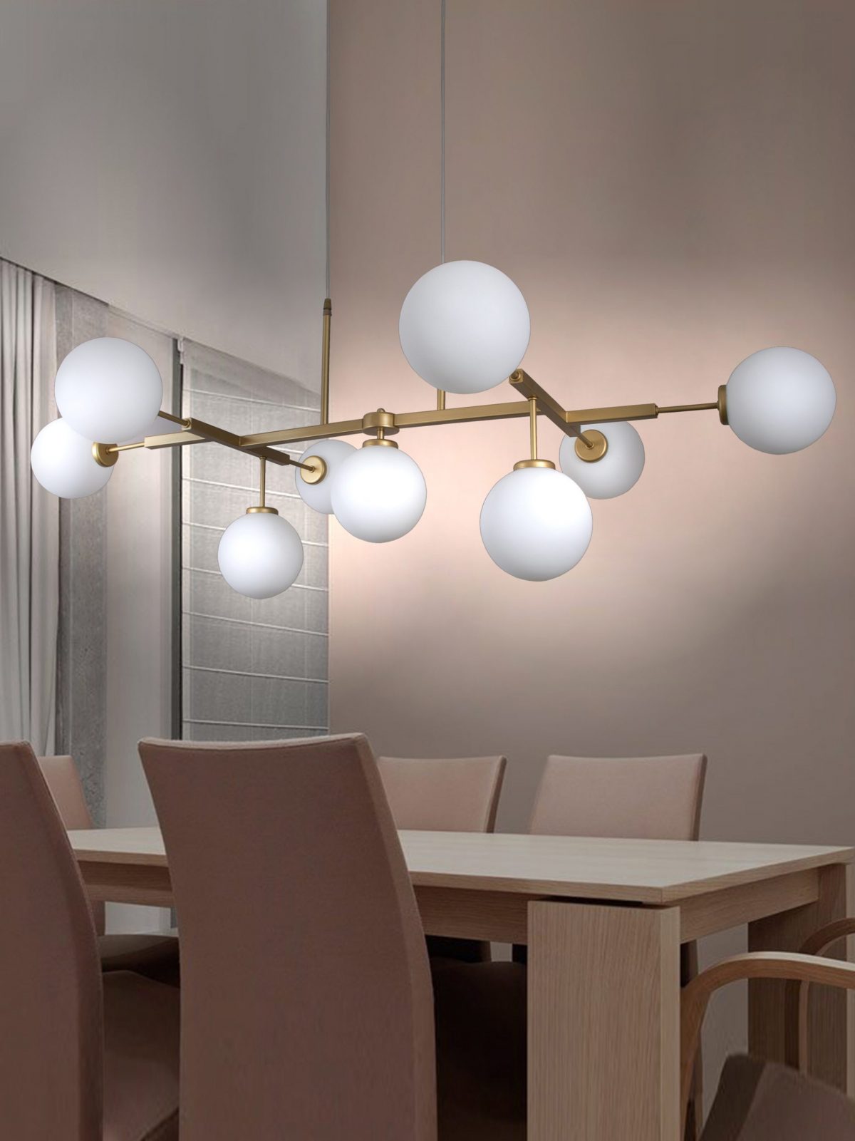 Un moderno comedor exhibe una mesa de madera y sillas beige bajo la impresionante Lámpara de techo en acero y oro Vela 7, que presenta ocho luces blancas esféricas sobre un marco dorado.