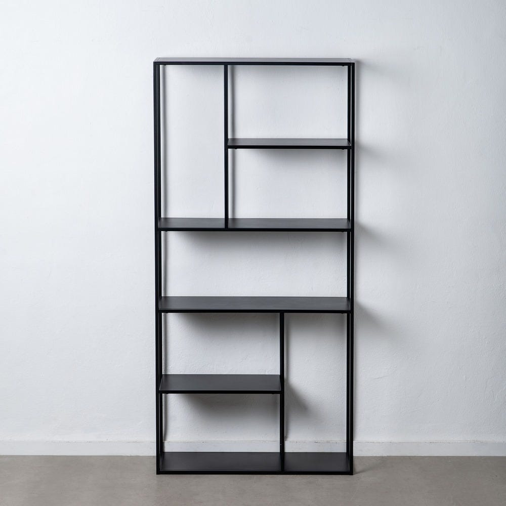 La Estantería Metálica Industrial Negro Square (Alta), una estantería alta de metal negro con un diseño asimétrico, ejemplifica el almacenamiento eficiente contra una pared blanca lisa sobre un piso gris.