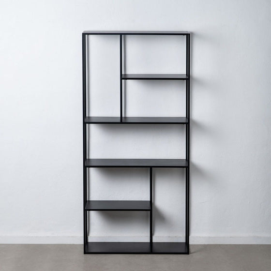 La Estantería Metálica Industrial Negro Square (Alta), una estantería alta de metal negro con un diseño asimétrico, ejemplifica el almacenamiento eficiente contra una pared blanca lisa sobre un piso gris.