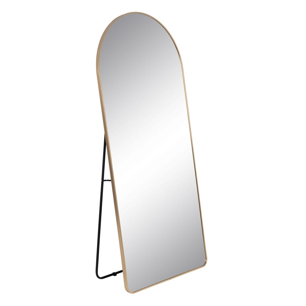 El Espejo de Aluminio Oro con Cristal Elegancia, un espejo arqueado de cuerpo entero con un elegante marco dorado y soporte negro, inclinado ligeramente hacia la derecha, personifica el diseño contemporáneo.